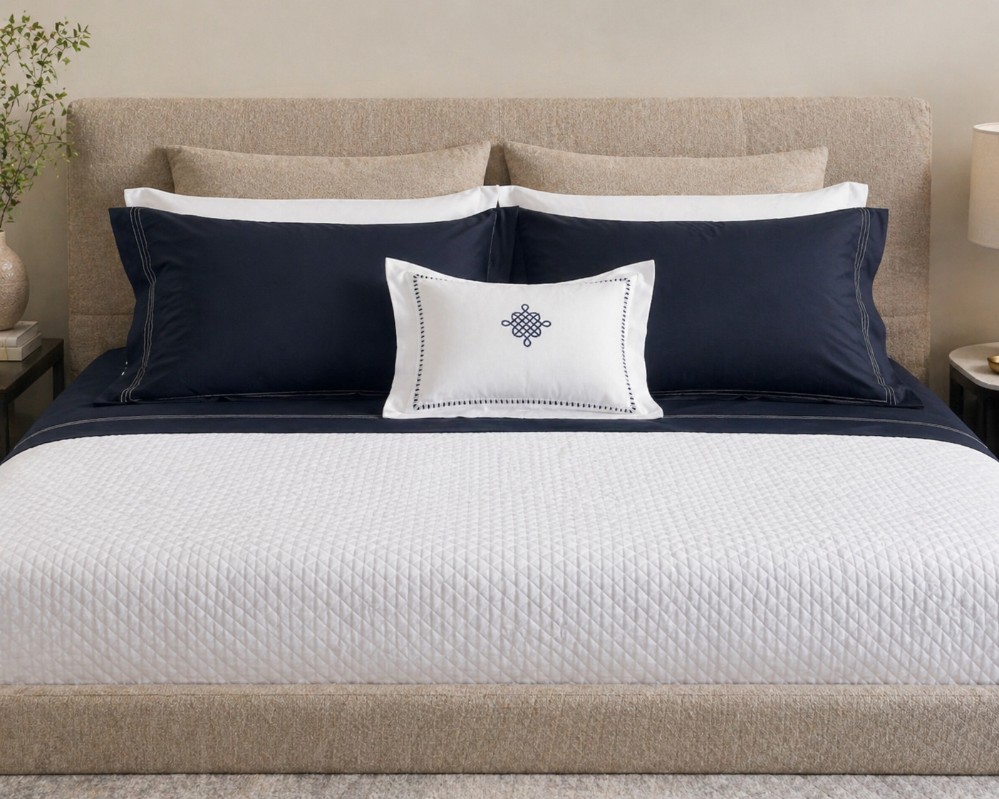 White Kearsley Narragansett Deep Sea triple stitch shams on Art Deco diamond matelassé coverlet with Soleil sateen pillowcases and Freya white and navy boudoir sham on a Poliform bed