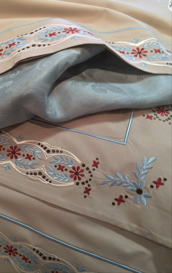 Duvet Cover of Taupe Essentials Percale with Tyrolean Embroidery in Pale blue, red, gold and brown.