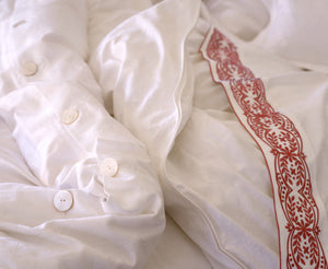 Kearsley Montecito Sateen top sheet with Red Tyrolean embroidery, paired with a Cortina White Jacquard duvet cover.