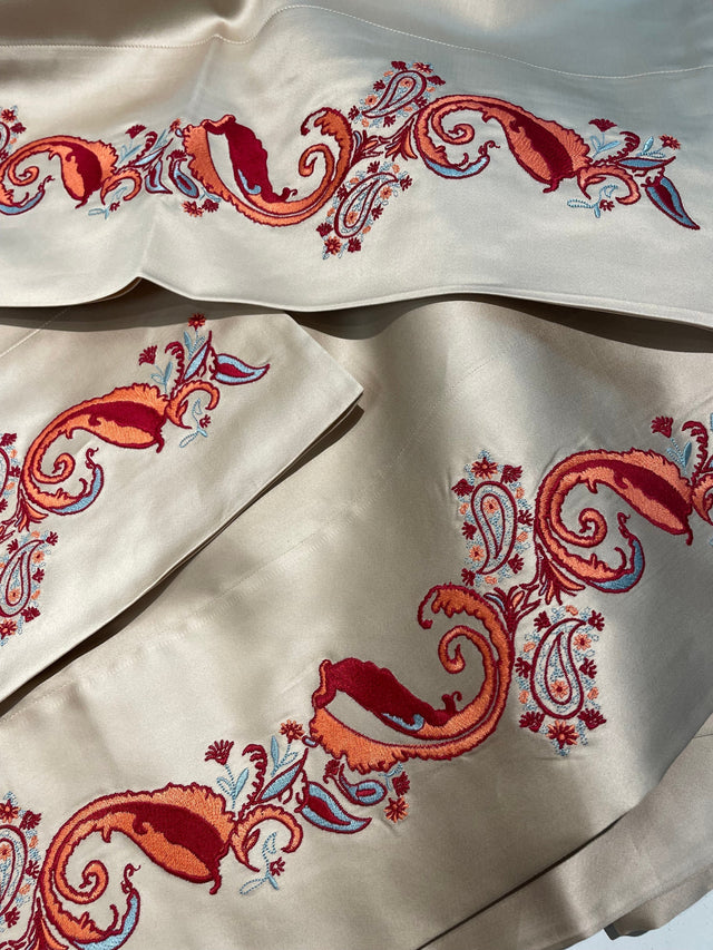 Kearsley Luxurious Montecito Sateen in a champagny silvery color we call Dream with Heather Kearsley Wolf designed Paisley in orange, brick red and a minty grean