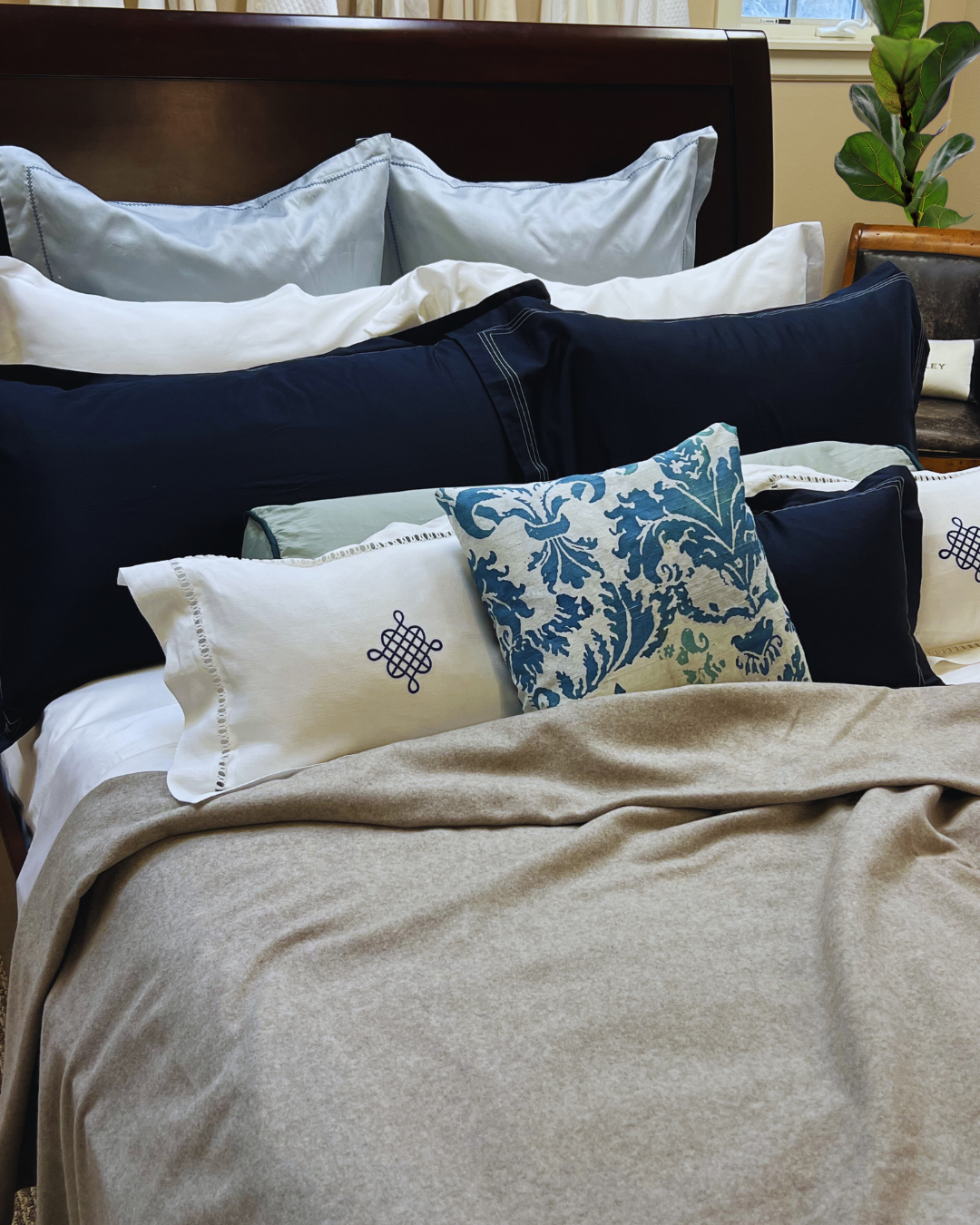 Made Kearsley Sleigh bed with Silver Grey St. Anton Cashmere blanket, Narragansett Deep sea pillow shams, Freya knot pillowshams and Stella embroidered Euro Shams.