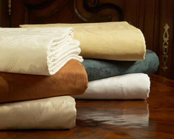 Shown is two stacks of three colors of he original Kearsley Cortina coton jaquard in Blonde, Evergreen, Ivory, White, Chestnut and Taupe.  Photo by WAb Studio.
