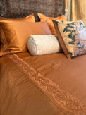 Rich cognac/brown duvet cover and Pillowcases with Tyrollean Embrdoeiry in matching tyrollean color.  Intricate beautiful rich embroidery  Anqtique Silk pillows in green and champagne with taupe bolster.  