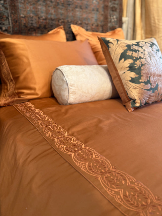 Rich cognac/brown duvet cover and Pillowcases with Tyrollean Embrdoeiry in matching tyrollean color.  Intricate beautiful rich embroidery  Anqtique Silk pillows in green and champagne with taupe bolster.  