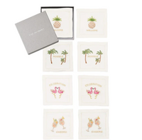 Photo of a set of eight white square Kim Seybert cocktail napkins embroidered with colorful pineapples, palm trees, flamingos, and cocktails, available at Kearsley.